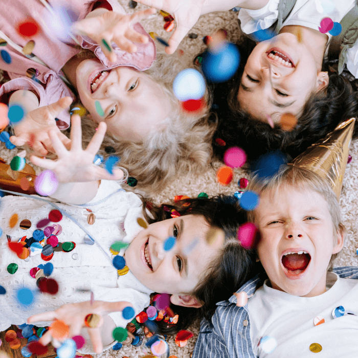 Grupo de niños riendo y jugando con confeti